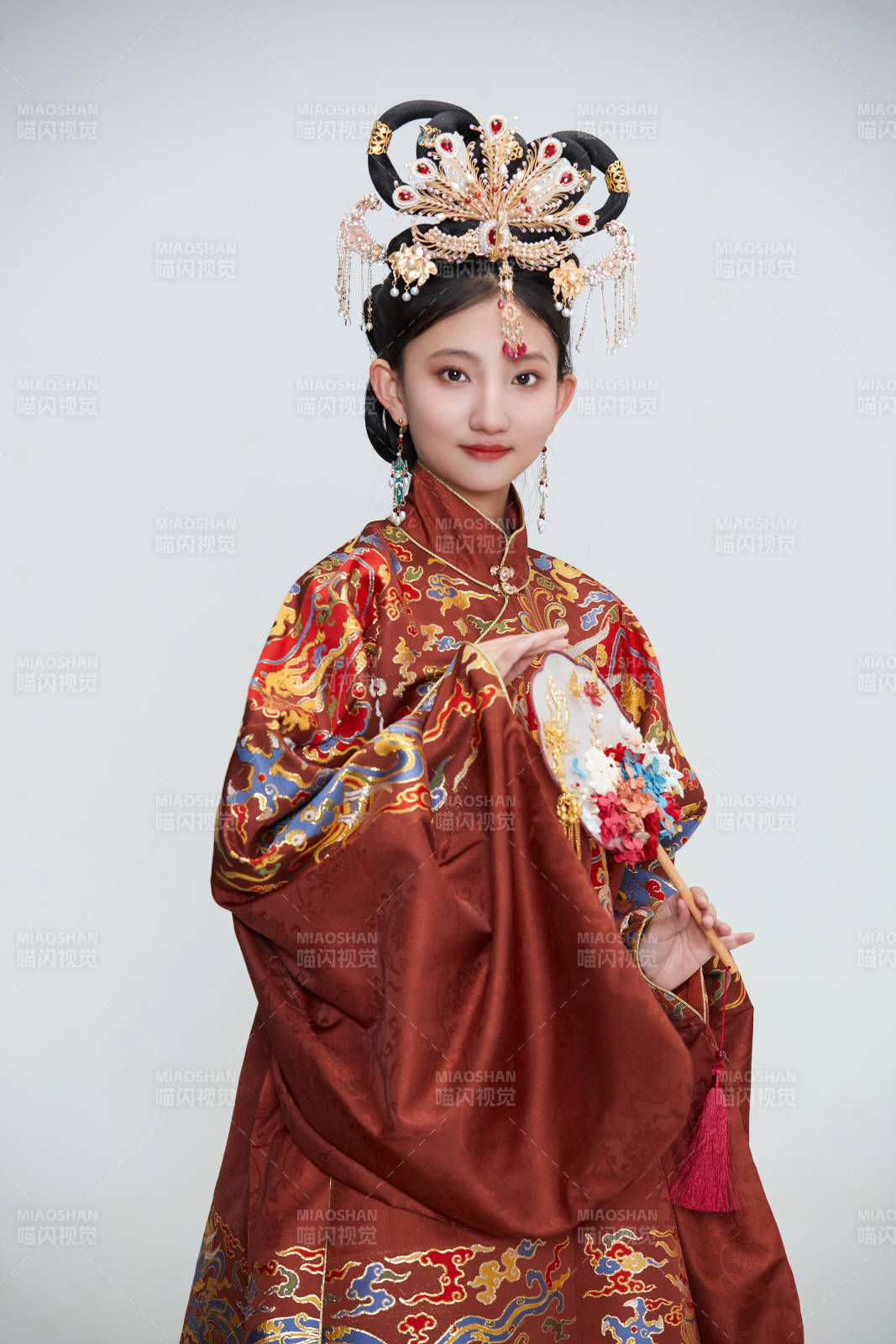 白色背景下穿着明代凤冠霞帔汉服的可爱少女图片