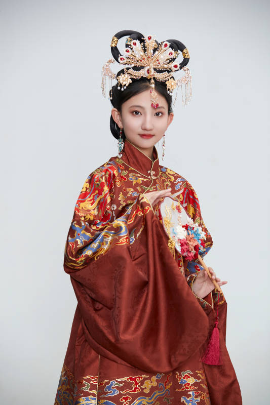 白色背景下穿着明代凤冠霞帔汉服的可爱少女图片