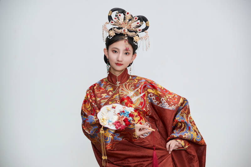 白色背景下穿着明代凤冠霞帔汉服的可爱少女图片