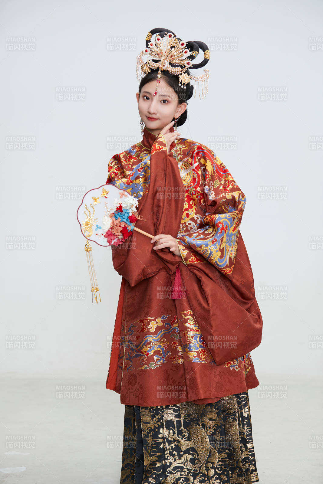 白色背景下穿着明代凤冠霞帔汉服的可爱少女图片