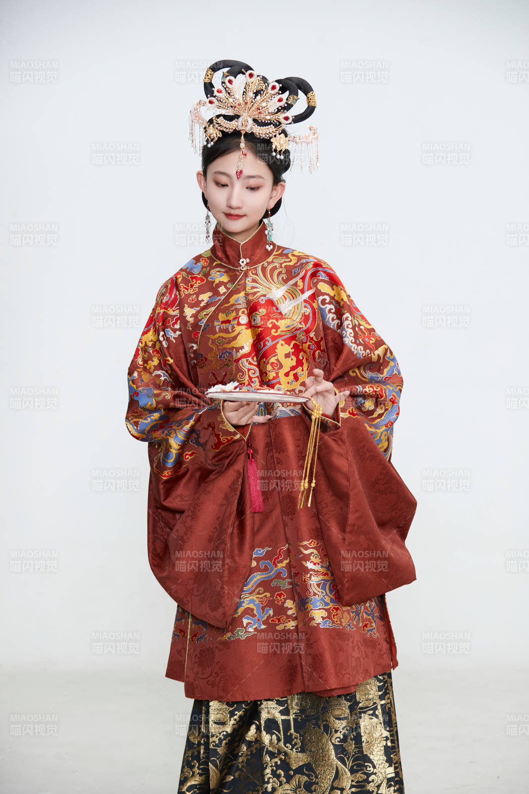 白色背景下穿着明代凤冠霞帔汉服的可爱少女图片