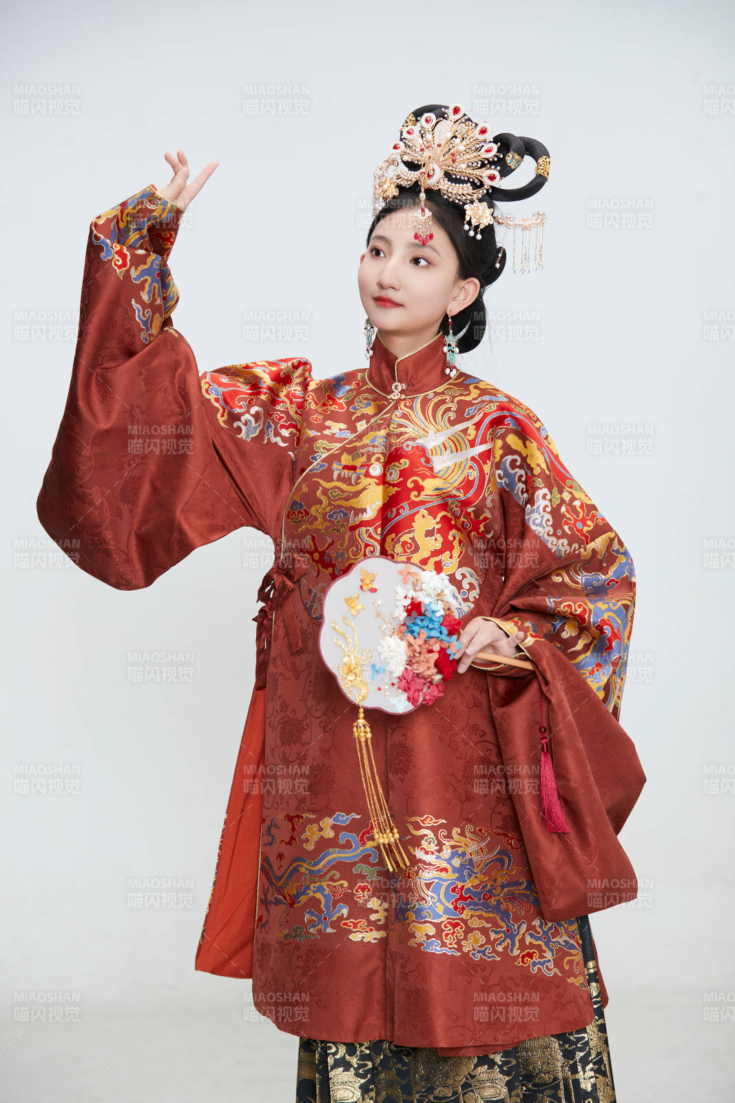 白色背景下穿着明代凤冠霞帔汉服的可爱少女图片