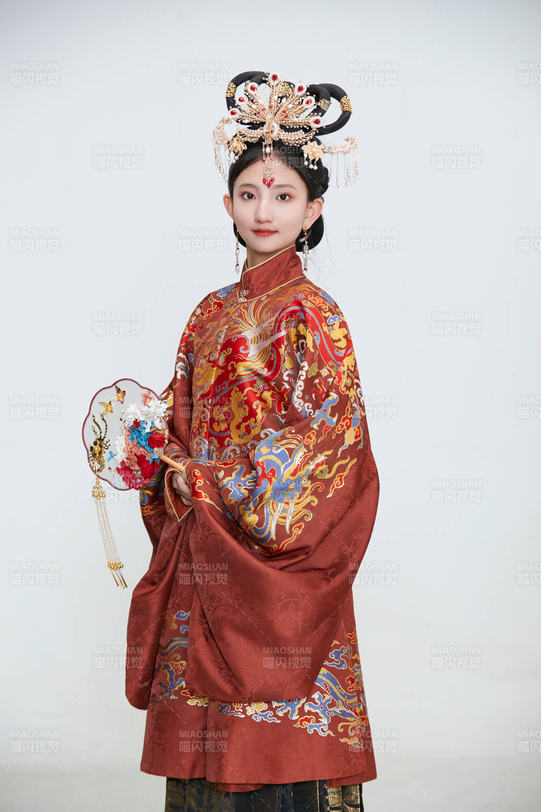 白色背景下穿着明代凤冠霞帔汉服的可爱少女图片