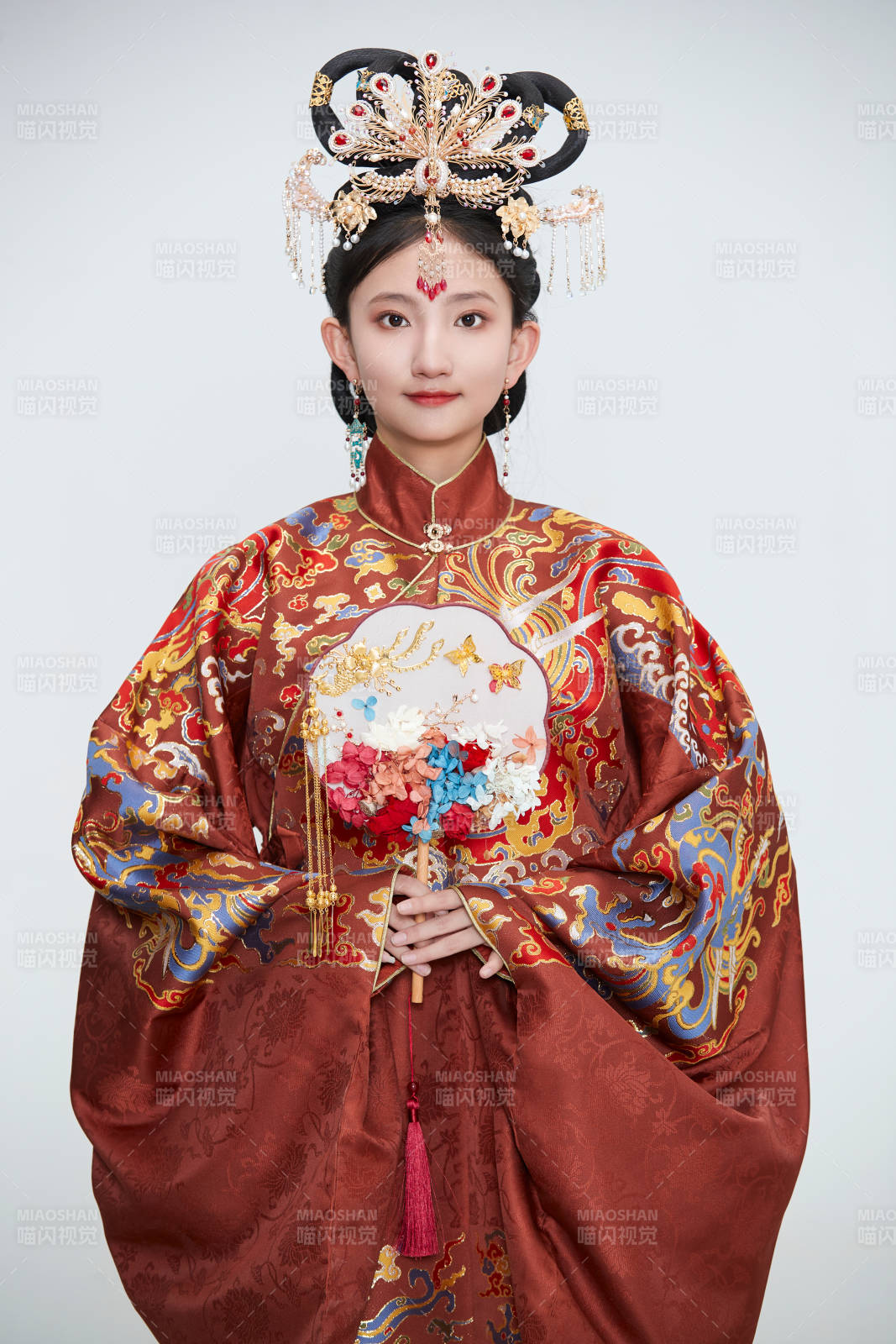 白色背景下穿着明代凤冠霞帔汉服的可爱少女图片