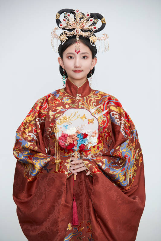 白色背景下穿着明代凤冠霞帔汉服的可爱少女图片