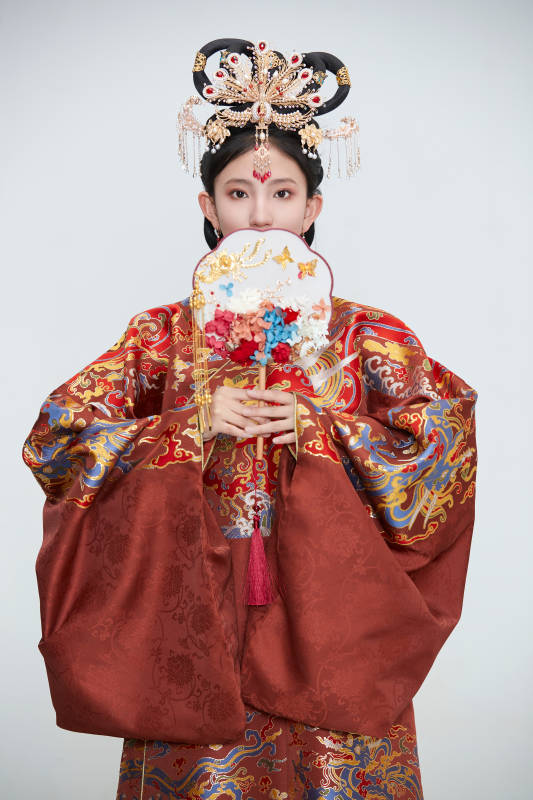 白色背景下穿着明代凤冠霞帔汉服的可爱少女图片