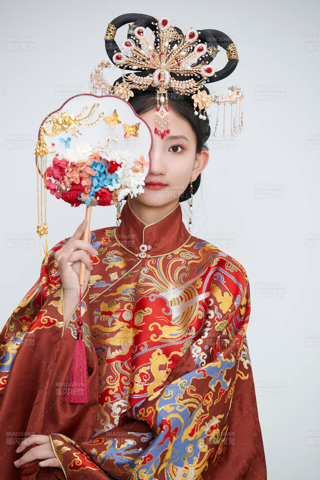 白色背景下穿着明代凤冠霞帔汉服的可爱少女图片