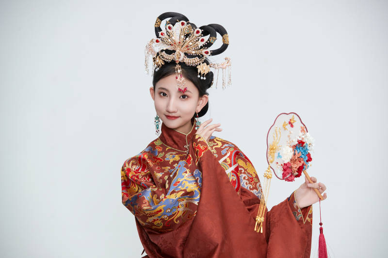 白色背景下穿着明代凤冠霞帔汉服的可爱少女图片