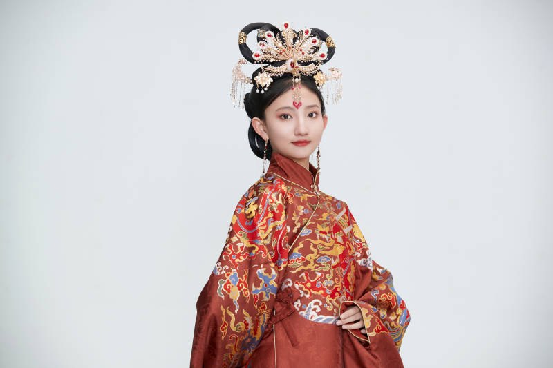 白色背景下穿着明代凤冠霞帔汉服的可爱少女图片