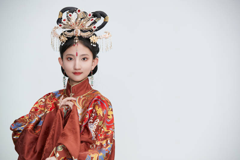 白色背景下穿着明代凤冠霞帔汉服的可爱少女图片