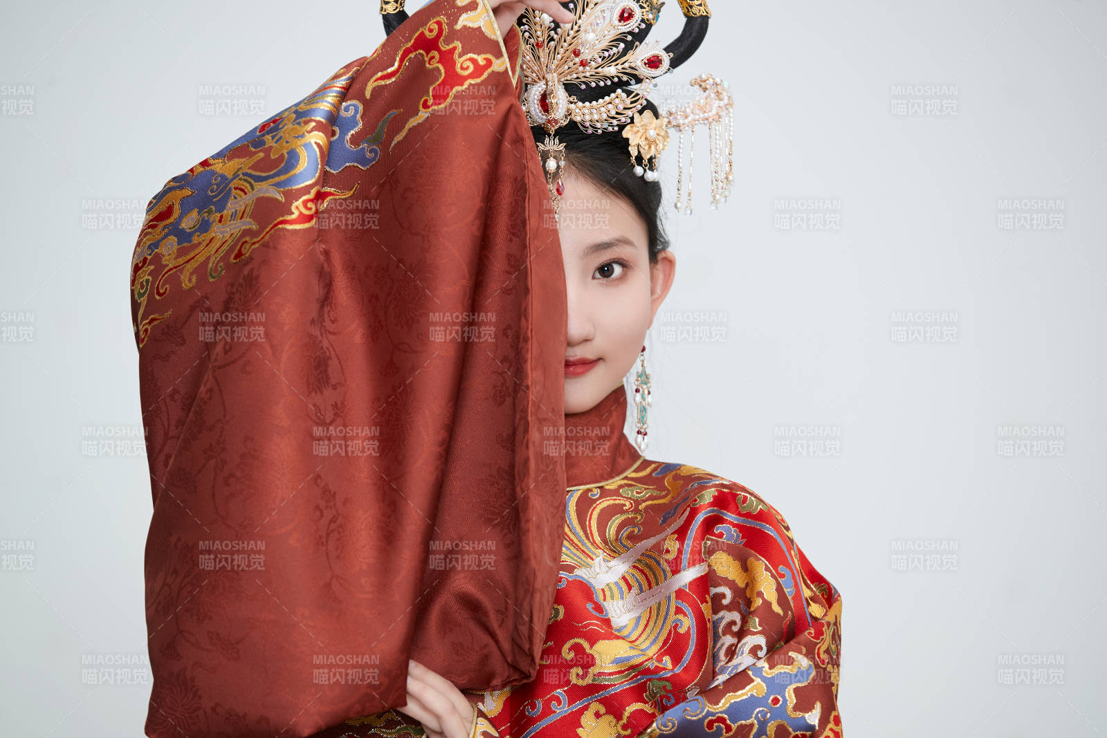 白色背景下穿着明代凤冠霞帔汉服的可爱少女图片