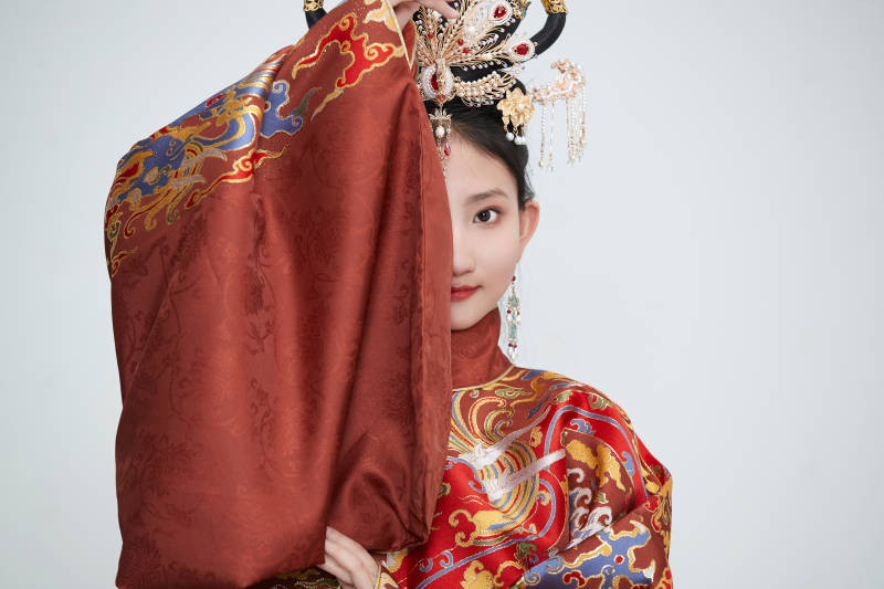 白色背景下穿着明代凤冠霞帔汉服的可爱少女图片