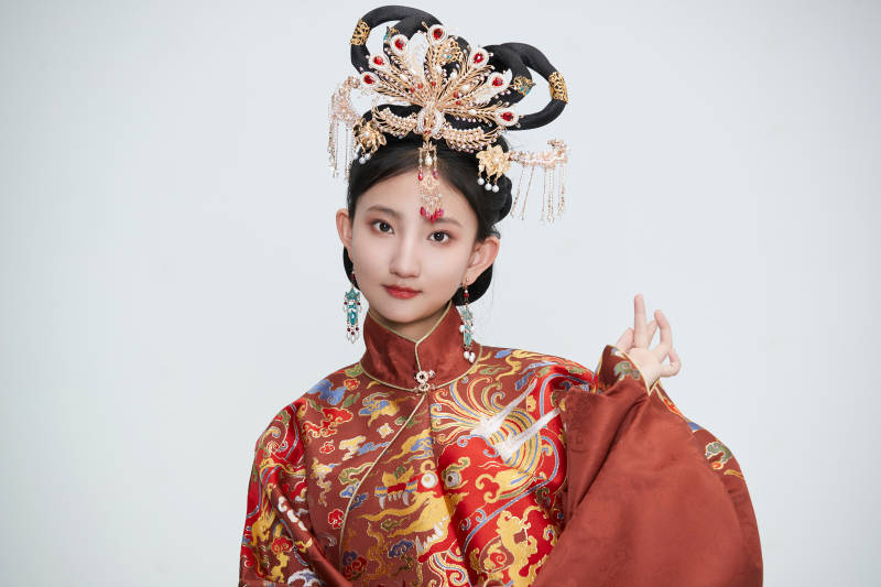 白色背景下穿着明代凤冠霞帔汉服的可爱少女图片