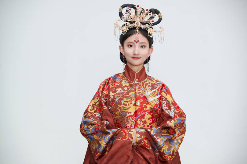 白色背景下穿着明代凤冠霞帔汉服的可爱少女图片