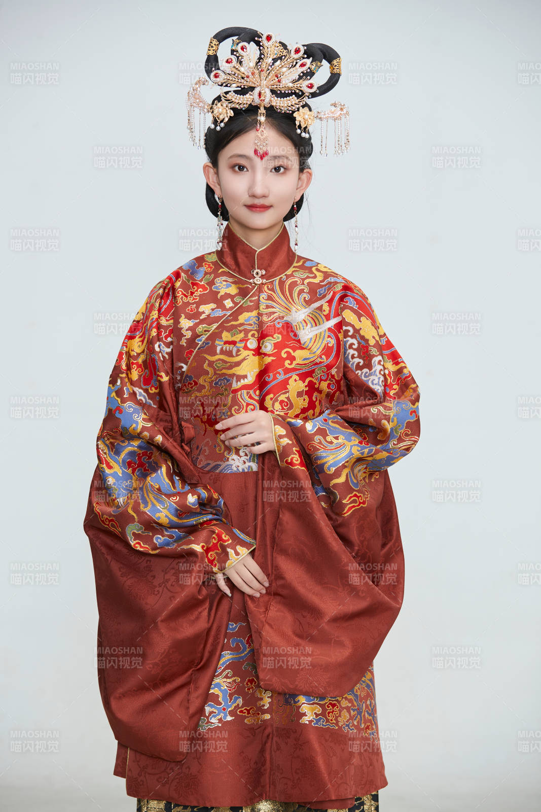白色背景下穿着明代凤冠霞帔汉服的可爱少女图片