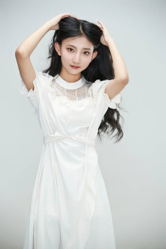 白色背景下身穿连衣裙的清纯少女图片