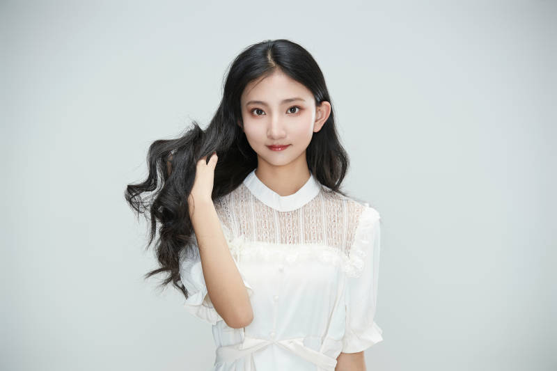 白色背景下身穿连衣裙的清纯少女图片