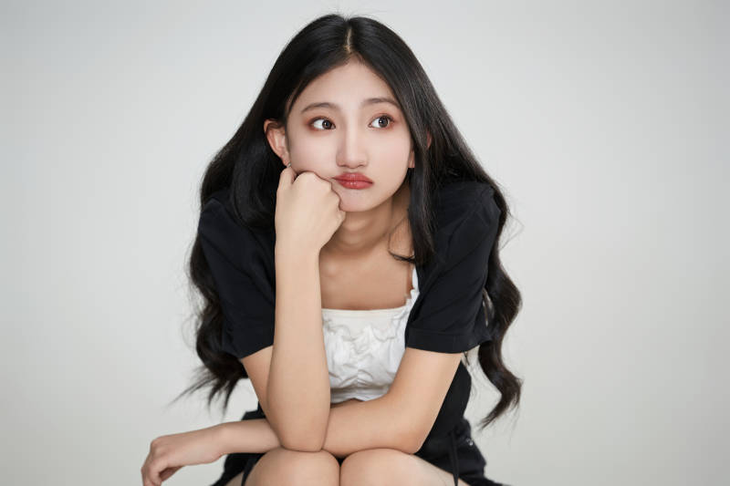 白色背景下做各种面部表情的可爱亚洲少女图片