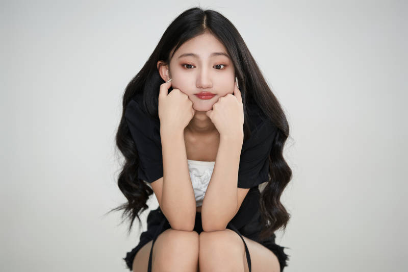 白色背景下做各种面部表情的可爱亚洲少女图片