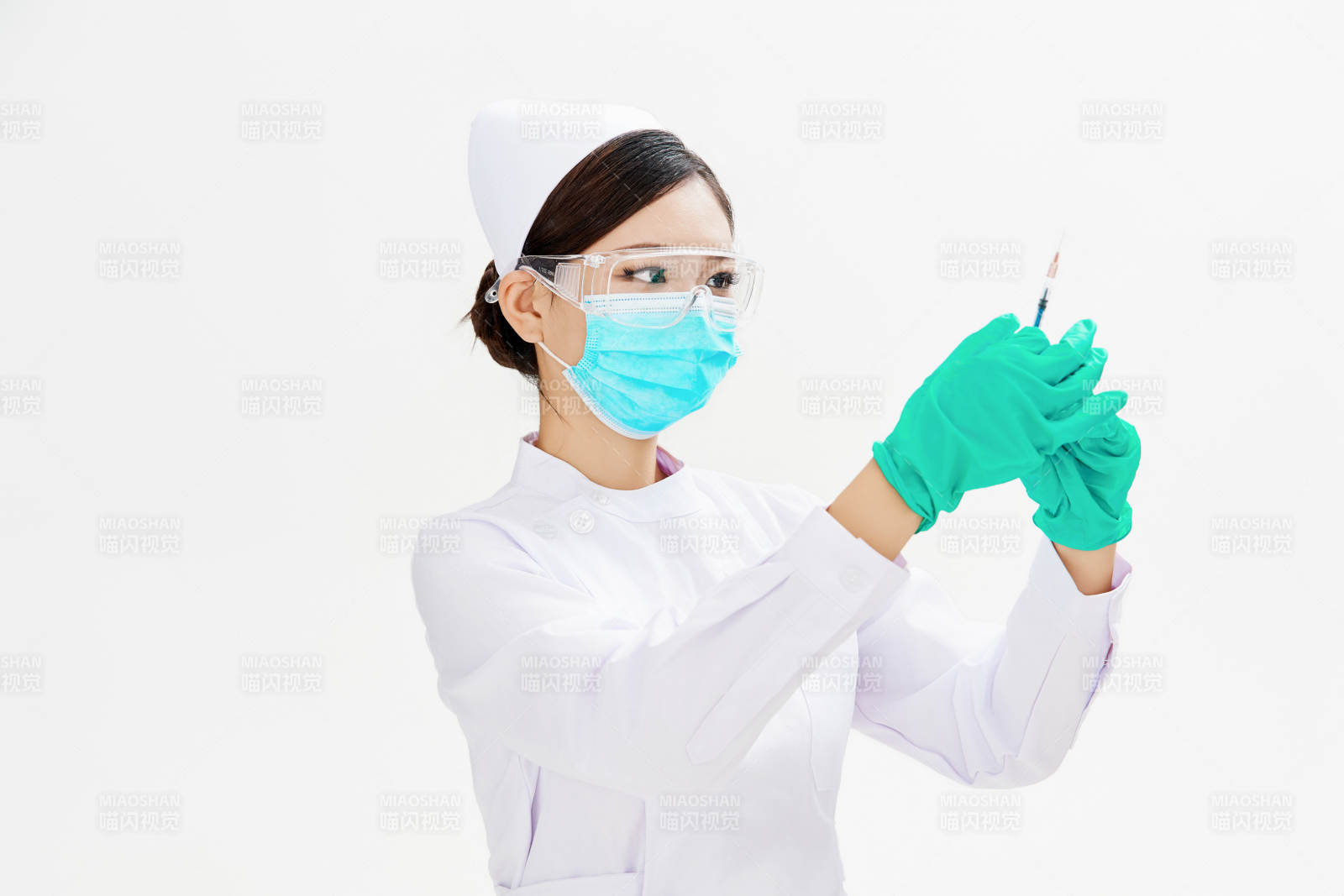 穿护士服戴口罩手执针筒的年轻女护士图片