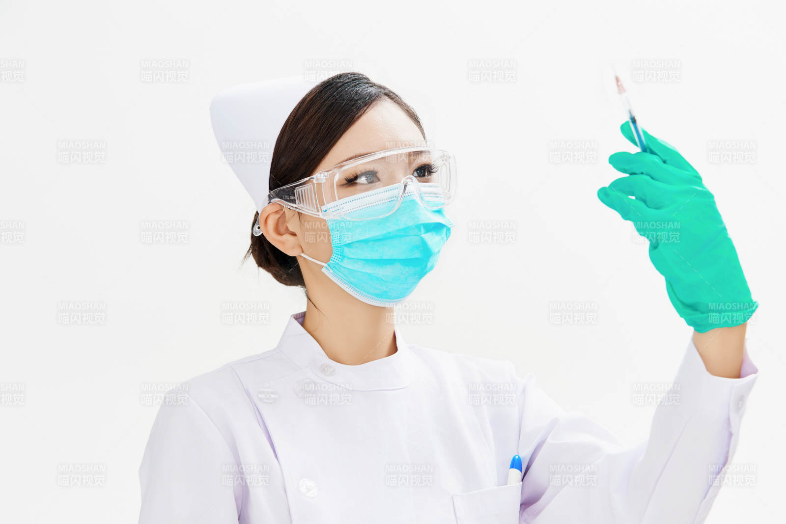 穿护士服戴口罩手执针筒的年轻女护士图片