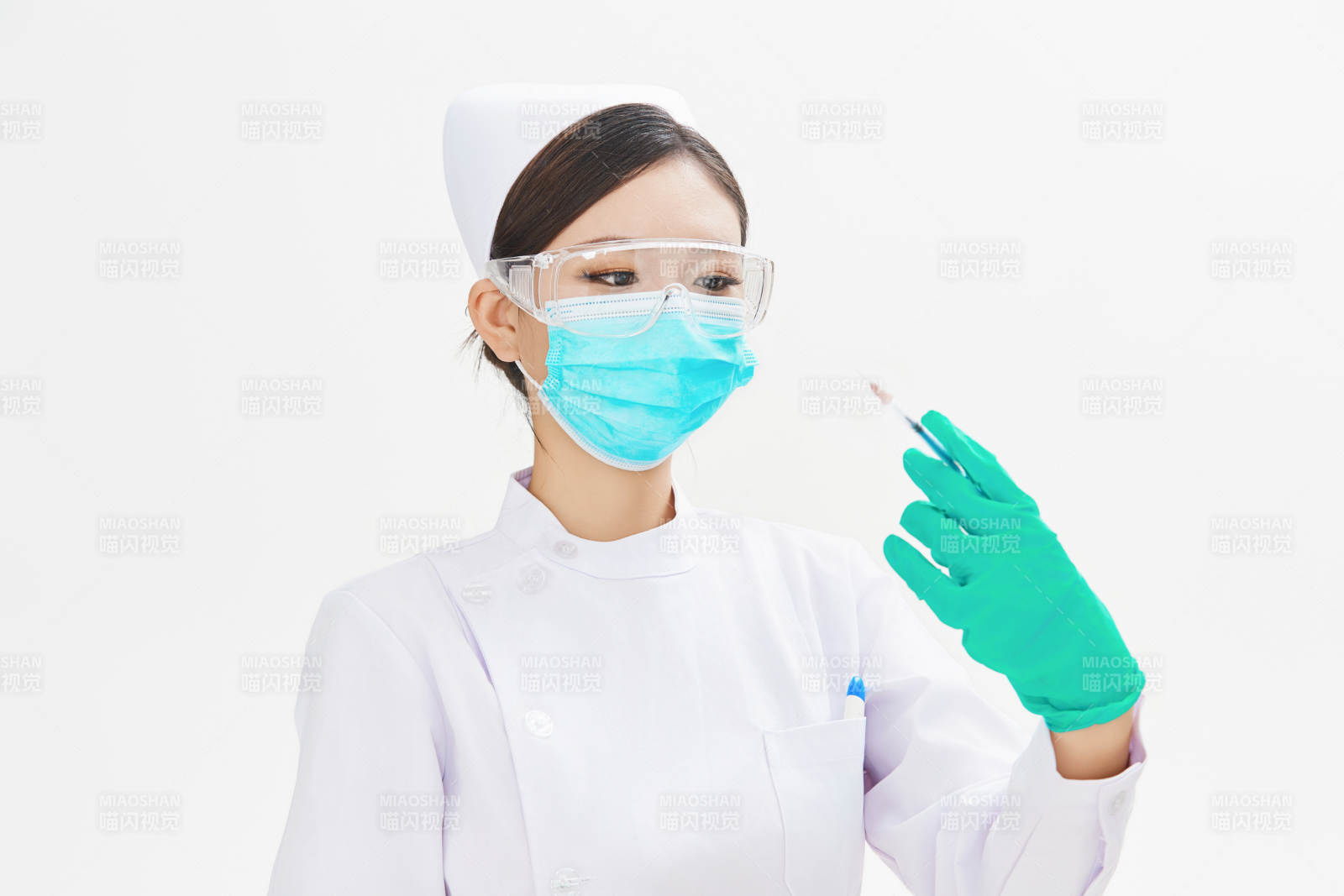穿护士服戴口罩手执针筒的年轻女护士图片