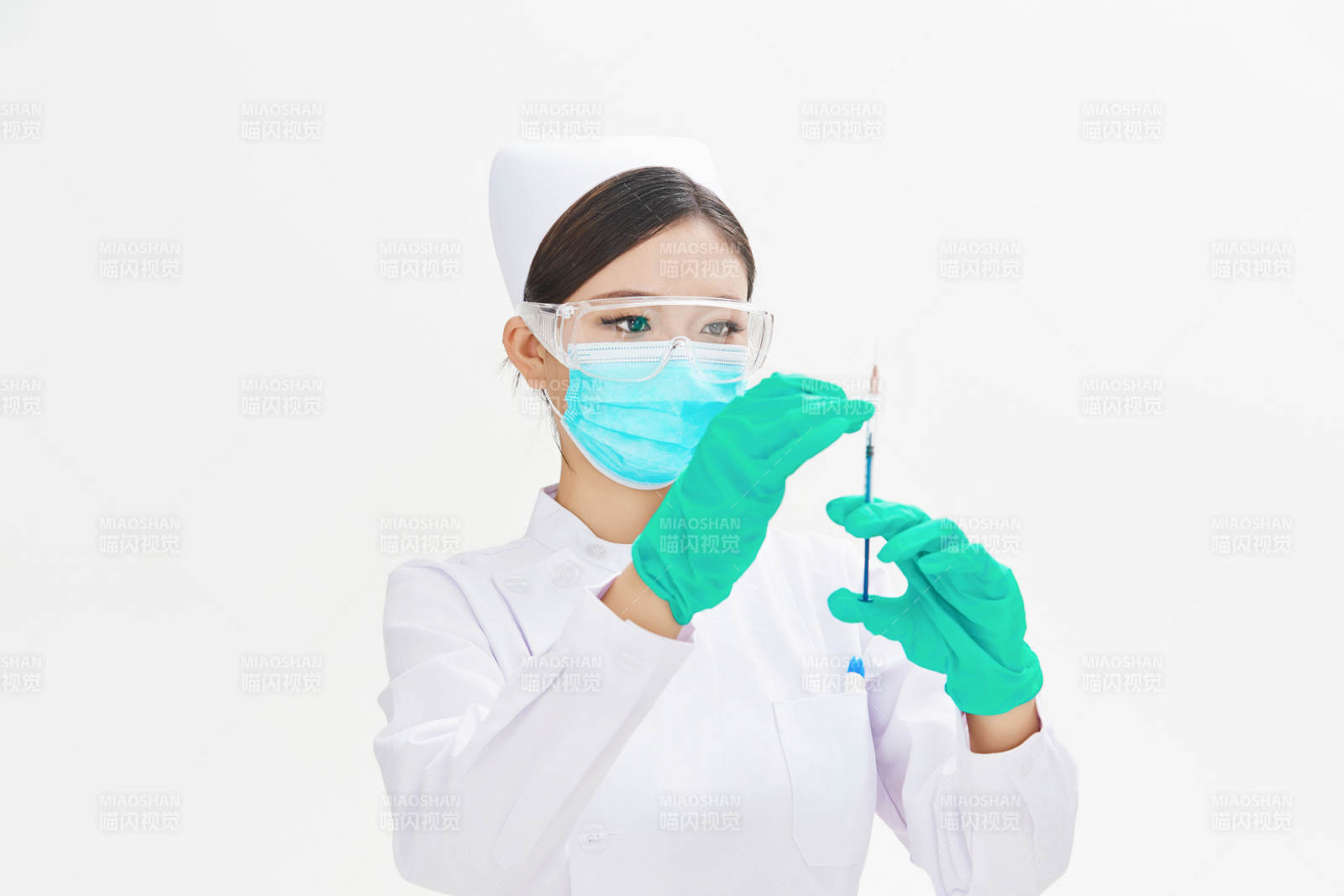 穿护士服戴口罩手执针筒的年轻女护士图片