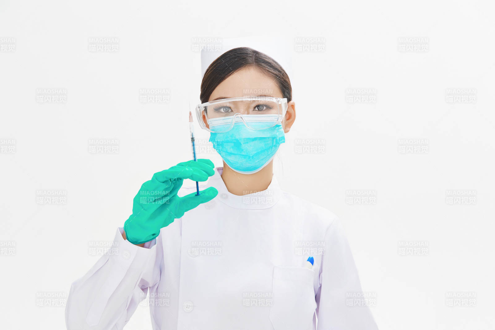 穿护士服戴口罩手执针筒的年轻女护士图片