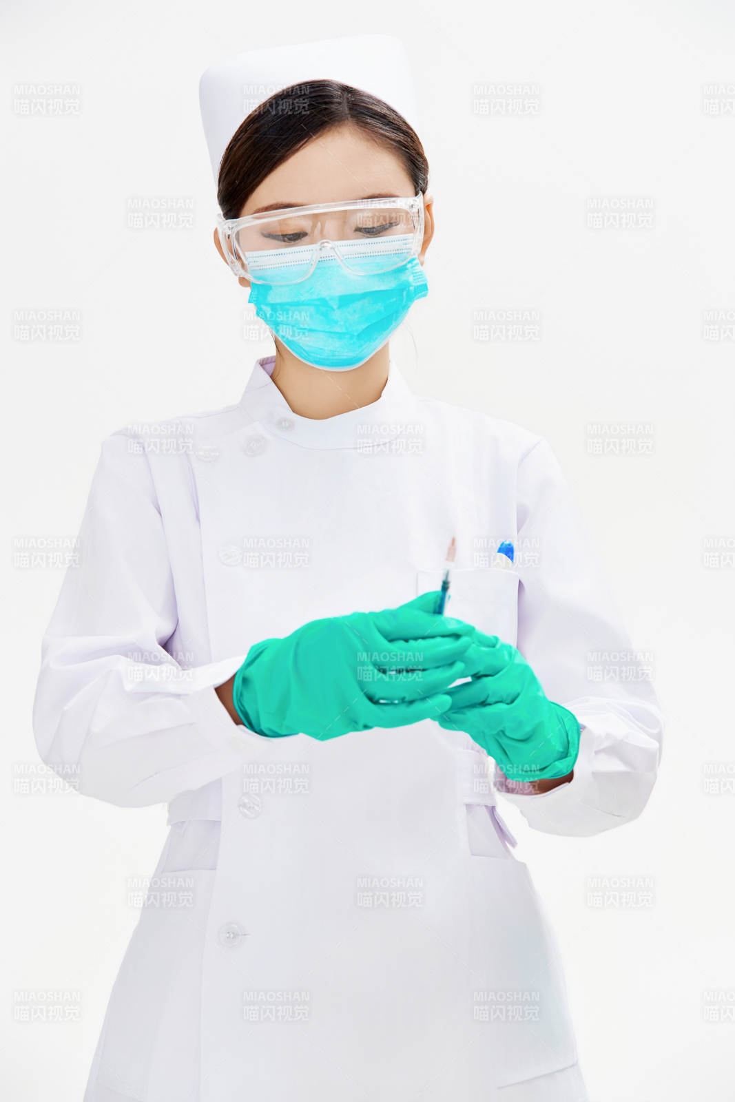 穿护士服戴口罩手执针筒的年轻女护士图片