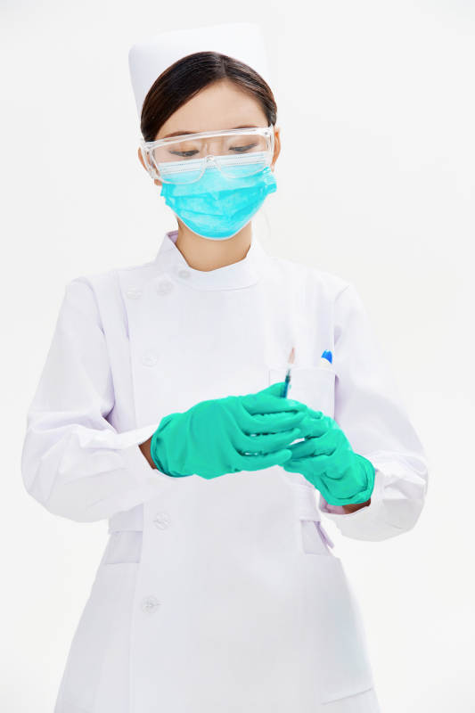 穿护士服戴口罩手执针筒的年轻女护士图片