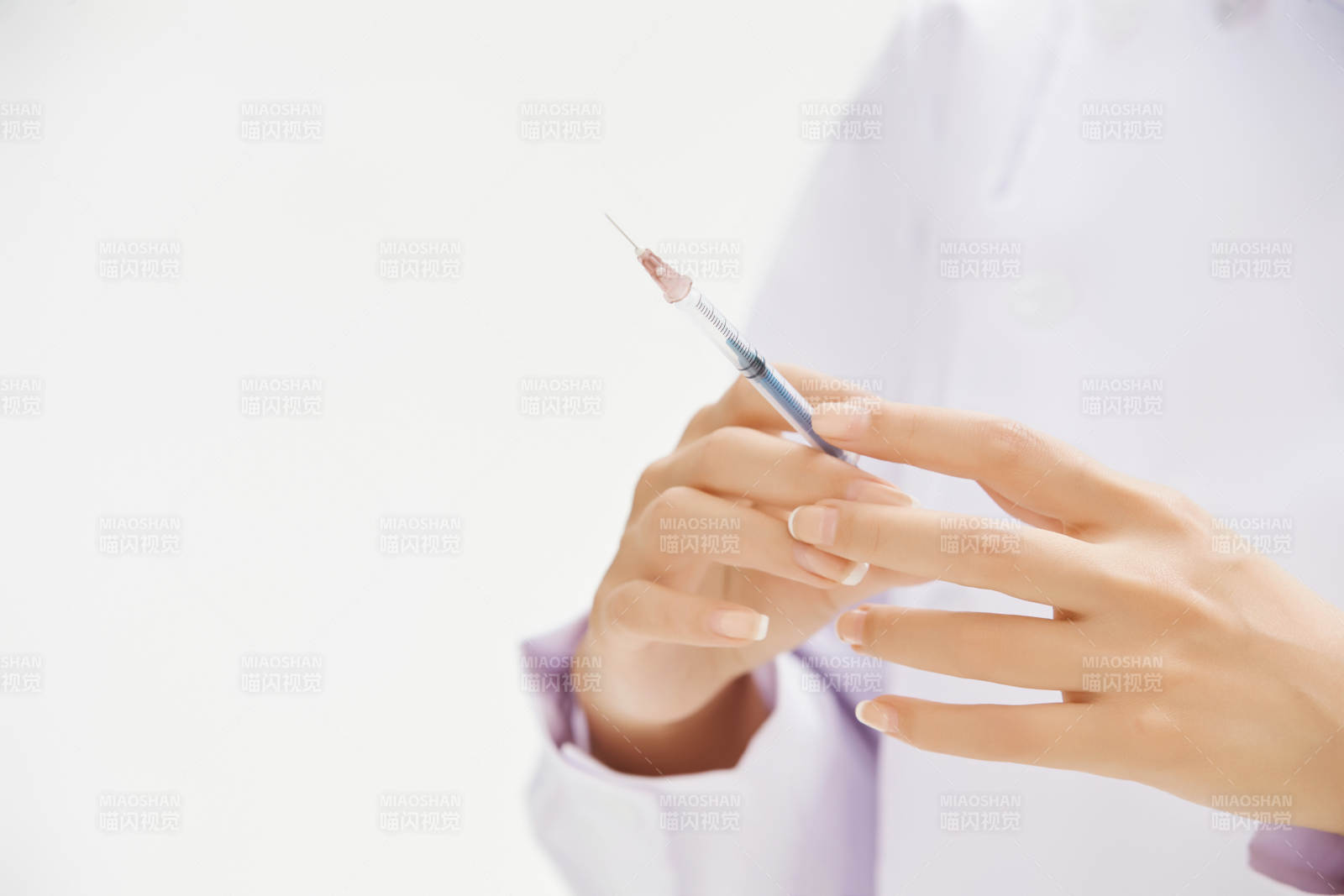 穿护士服戴口罩手执针筒的年轻女护士图片