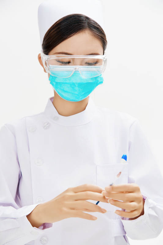 穿护士服戴口罩手执针筒的年轻女护士图片