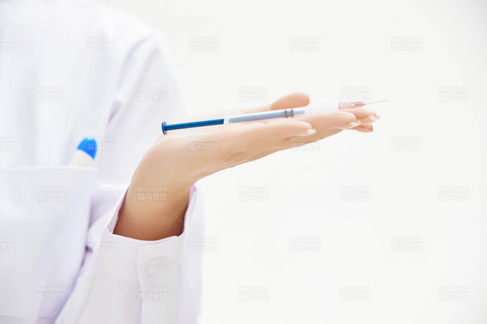 穿护士服戴口罩手执针筒的年轻女护士图片