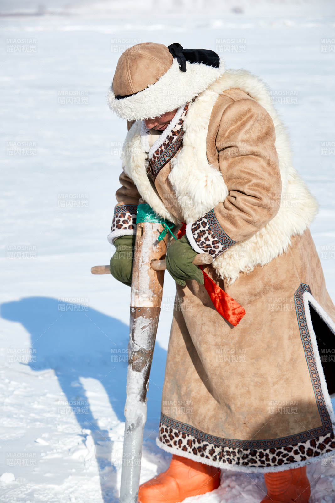 寒冷的冬季在冰冻的湖面上凿冰捕鱼的人们图片