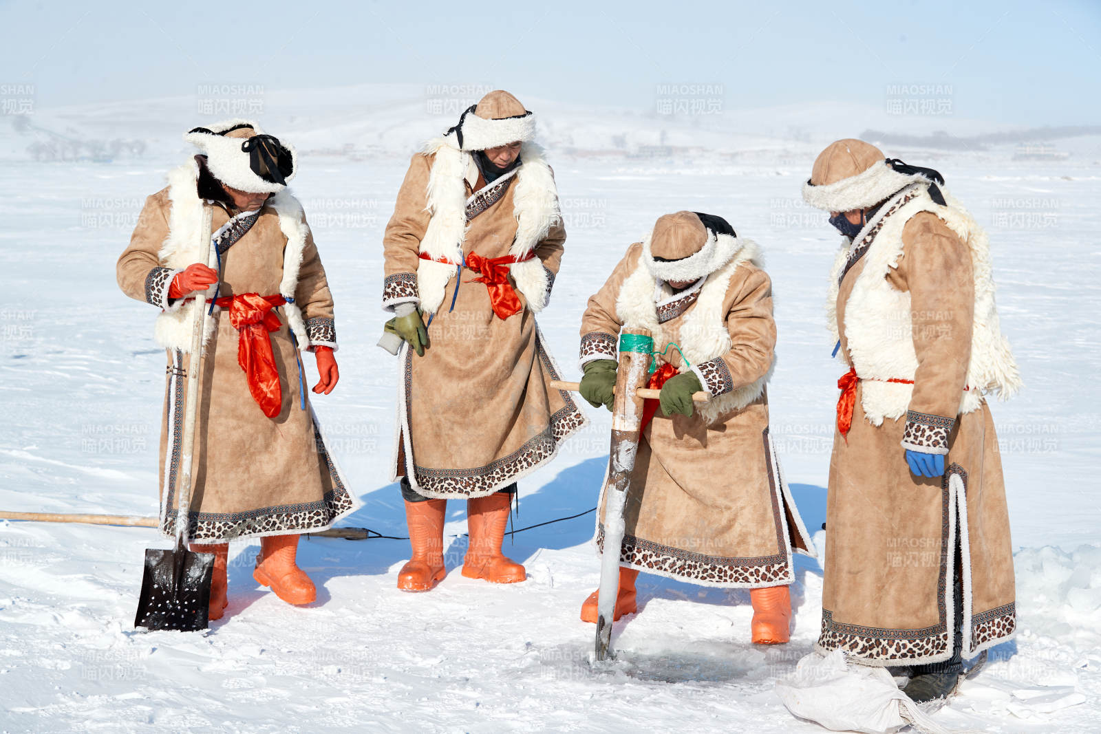 寒冷的冬季在冰冻的湖面上凿冰捕鱼的人们图片