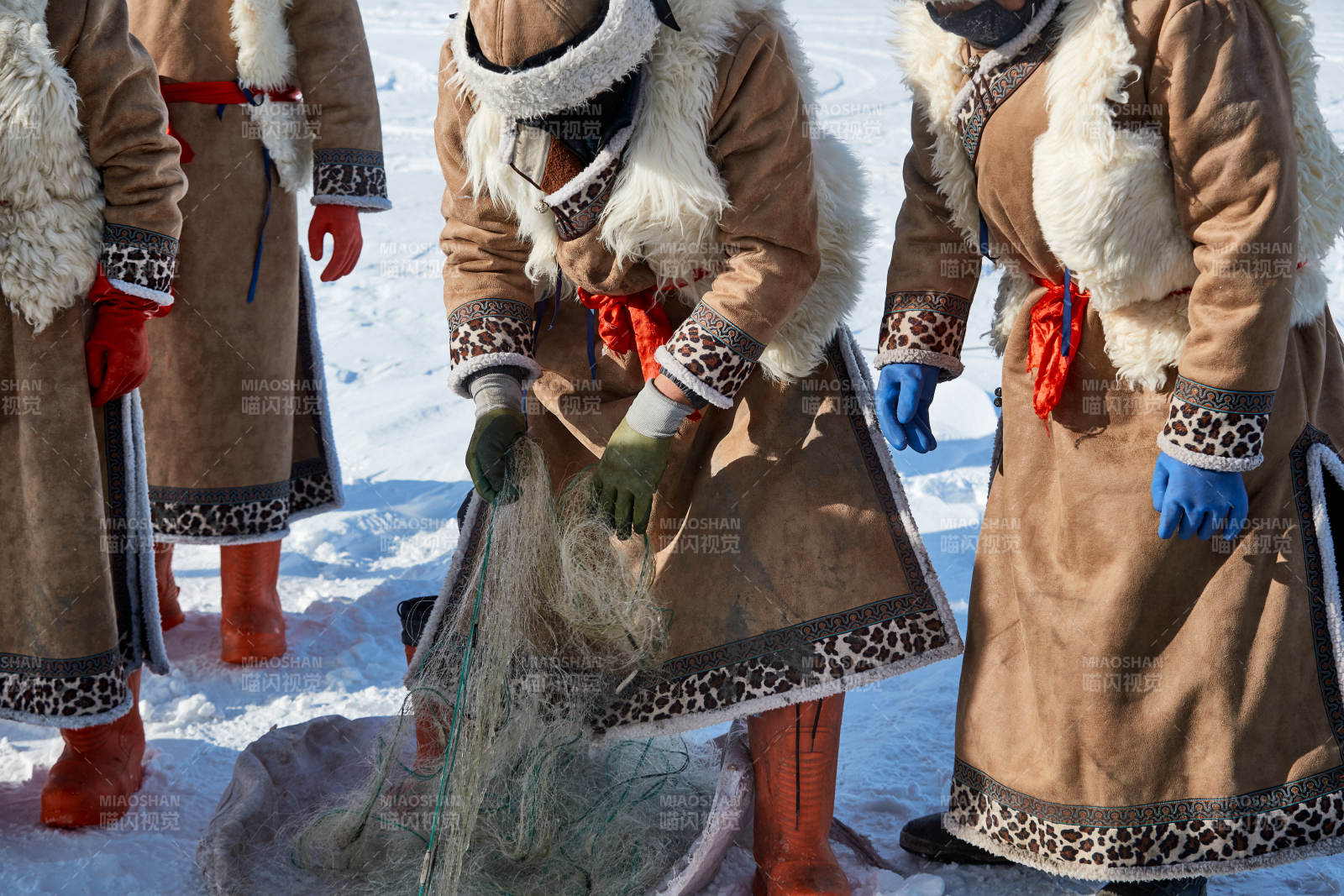 寒冷的冬季在冰冻的湖面上凿冰捕鱼的人们图片