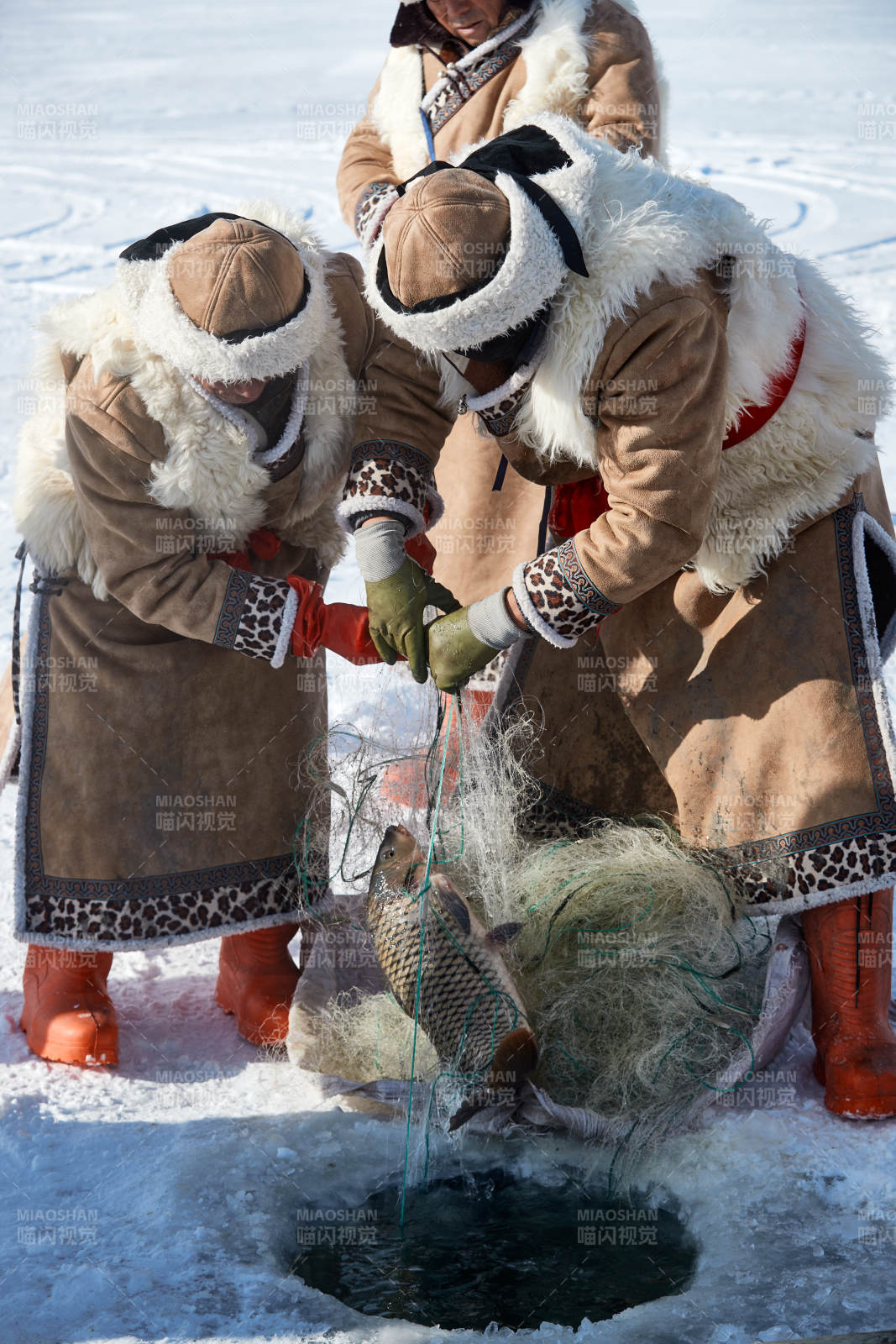 寒冷的冬季在冰冻的湖面上凿冰捕鱼的人们图片