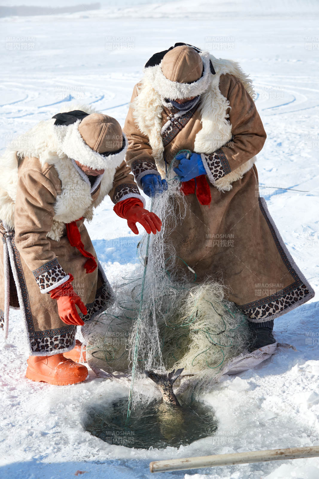 寒冷的冬季在冰冻的湖面上凿冰捕鱼的人们图片