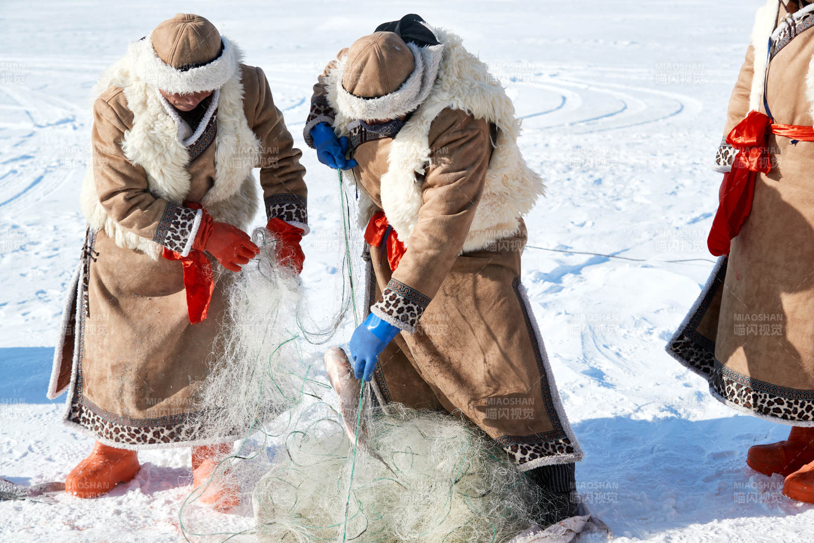 寒冷的冬季在冰冻的湖面上凿冰捕鱼的人们图片