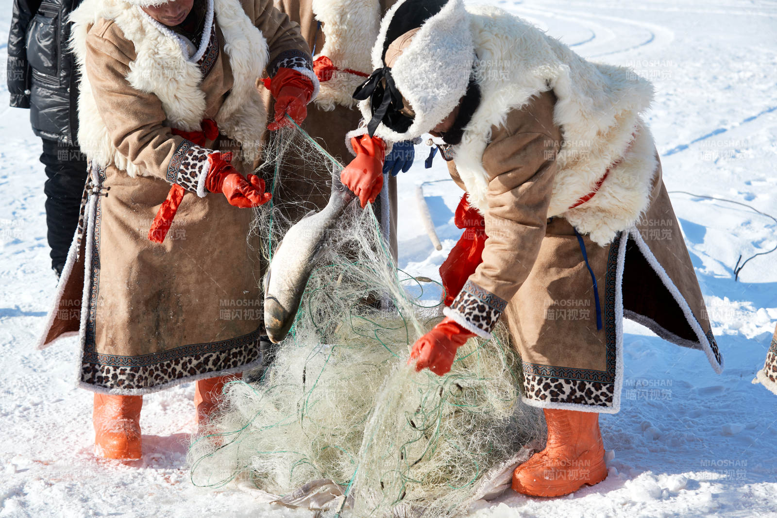 寒冷的冬季在冰冻的湖面上凿冰捕鱼的人们图片