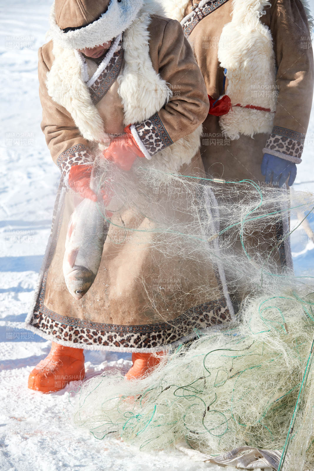 寒冷的冬季在冰冻的湖面上凿冰捕鱼的人们图片
