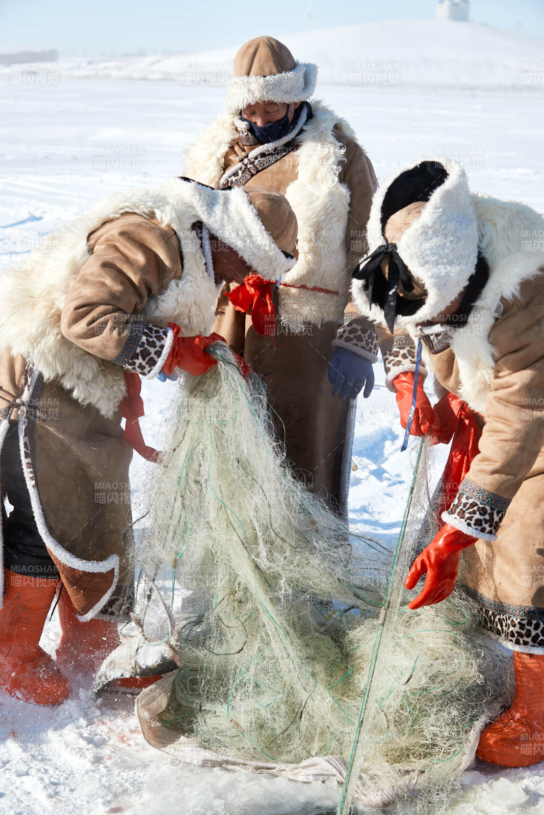 寒冷的冬季在冰冻的湖面上凿冰捕鱼的人们图片