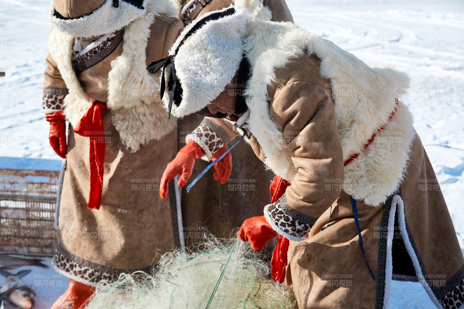 寒冷的冬季在冰冻的湖面上凿冰捕鱼的人们图片