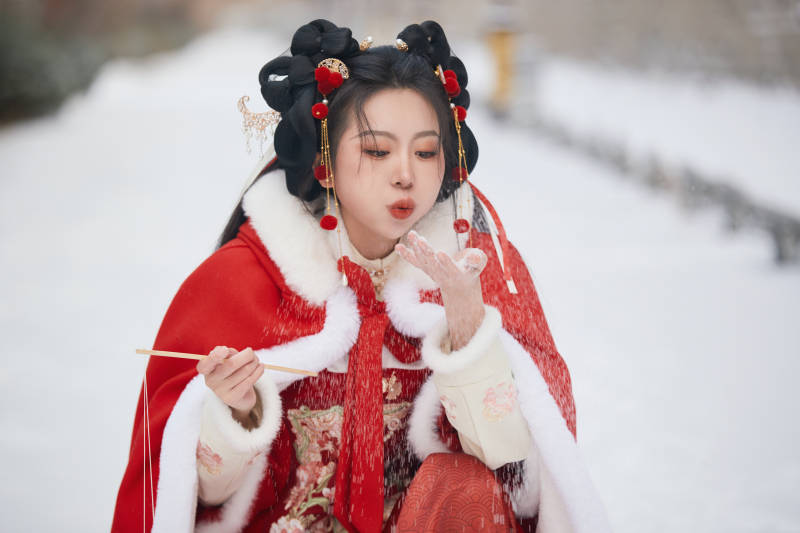 雪天户外身穿中式红色汉服的亚洲少女图片