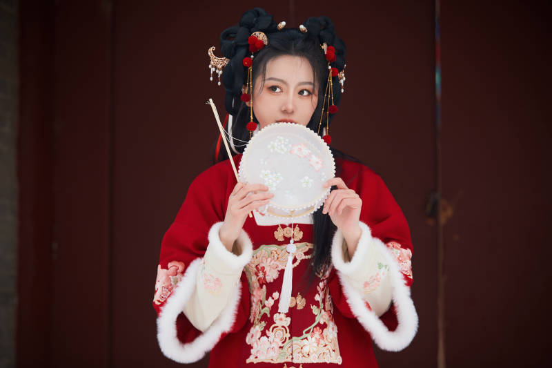 雪天户外身穿中式红色汉服的亚洲少女图片