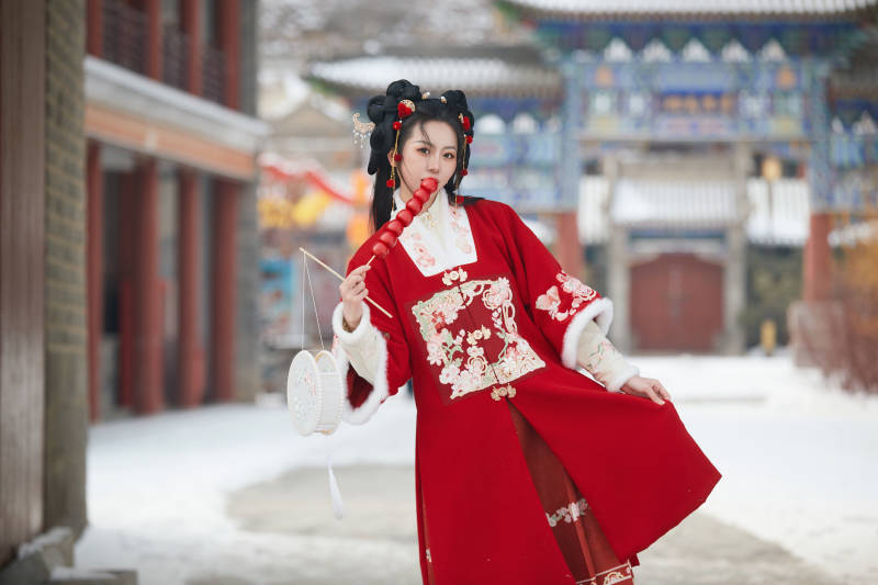 雪天户外身穿中式红色汉服的亚洲少女图片