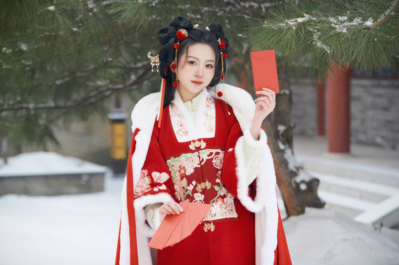 雪天户外身穿中式红色汉服的亚洲少女图片