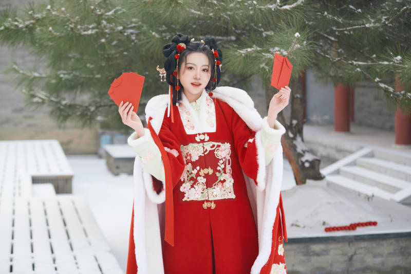 雪天户外身穿中式红色汉服的亚洲少女图片