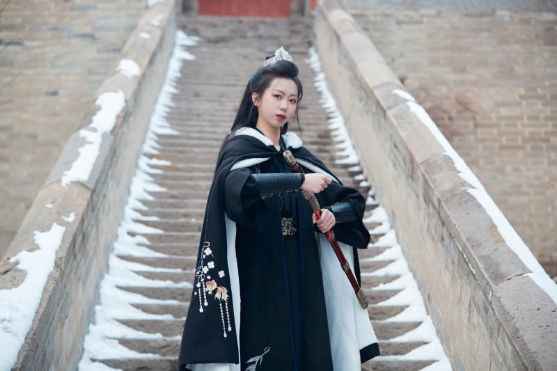 雪天古城身穿汉服扮演武侠的中国少女图片