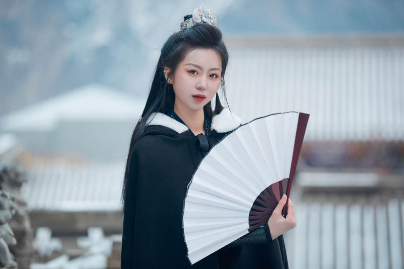 雪天古城身穿汉服扮演武侠的中国少女图片